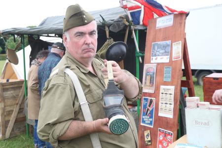 Man dressed as a World War 2 solider holding a gas mask