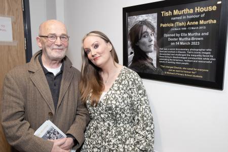 Mick Henry, former lecturer at Bath Lane college and Ella Murtha next to the commemorative naming plaque for Tish Murtha House