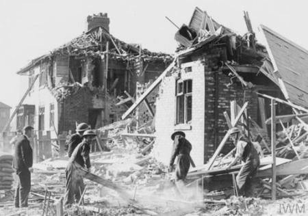 Fire and home guard officers removing wood and rubble from a home that has been bombed in High Heaton in September 1940