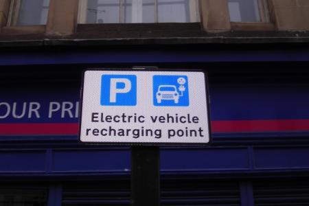 Sign adjacent to the bay, the sign has a picture of a car charging and states’ Electric vehicle recharging point’