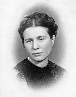 Black and white, head and shoulders photo of Irena Sendler. She wears a round neck dress and her hair is in plaits pinned over the top of her head