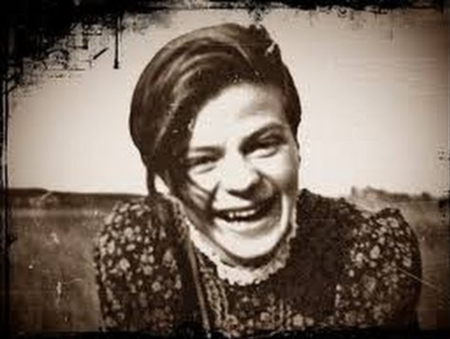 Sophie Scholl photographed in a field or park and smiling towards the camera