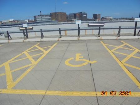 Disabled bays within a car park, bays are marked in yellow with the disabled symbol in the middle of the parking bay and a sign at the front of the bay