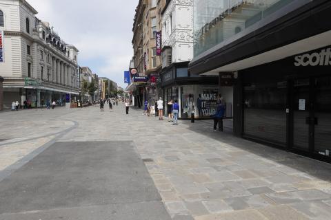 Photo showing a long view of a pedestrian street with a small number of people.