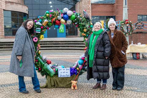 Image of a large Xmas wreathe with people in the shot