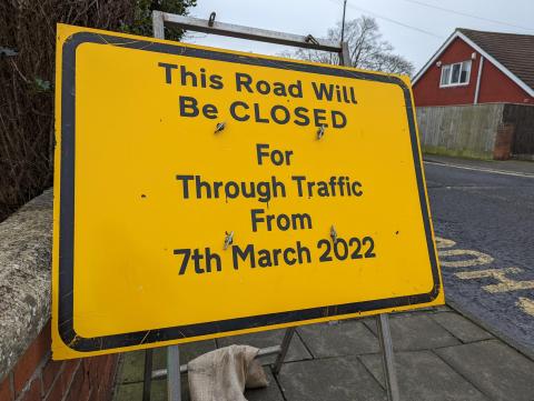 Image of yellow sign closing a road to vehicles