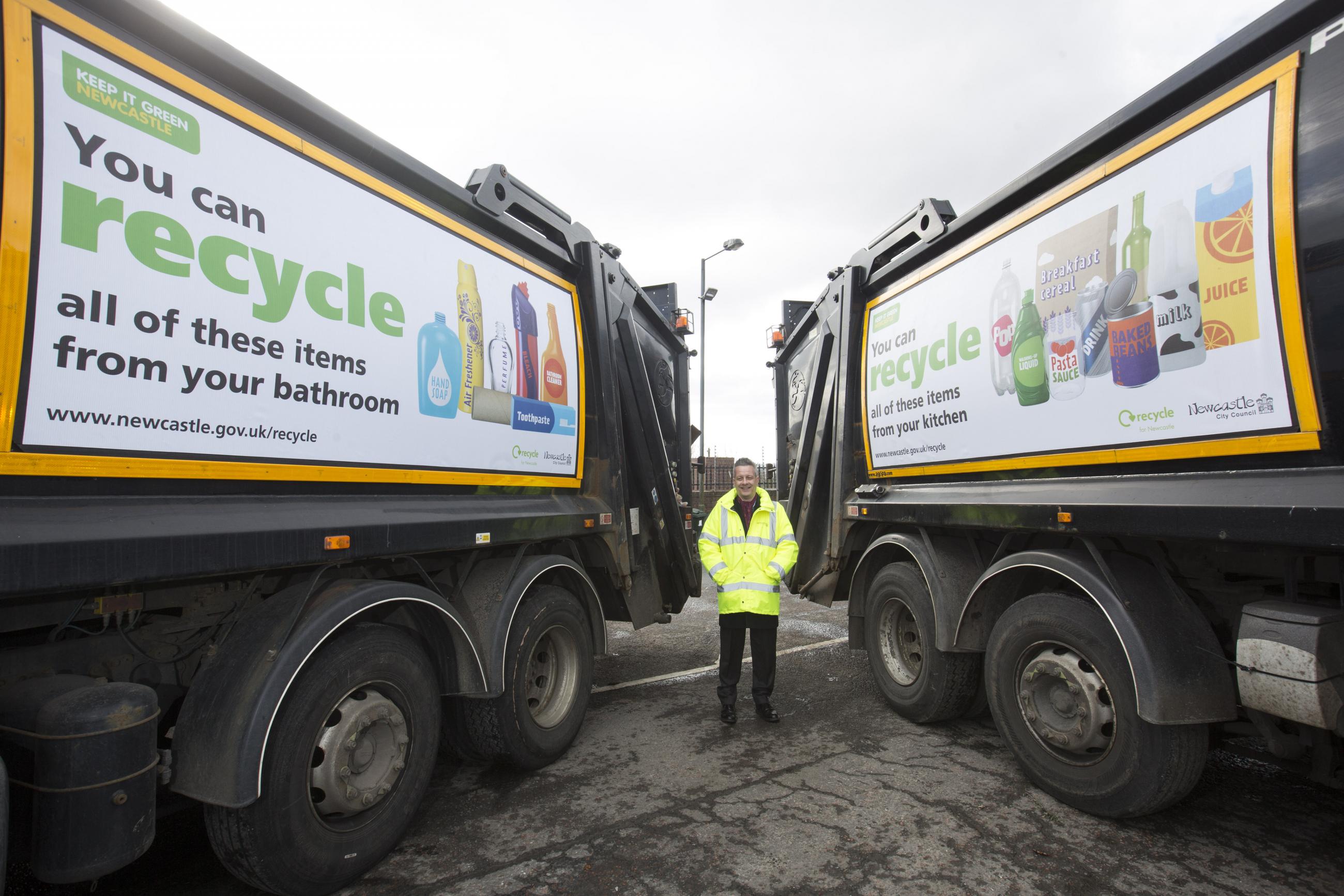 Cllr Nick Kemp photographed with the current fleet of recycling wagons. 