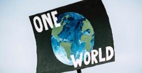 A protest sign showing a globe and declaring One World